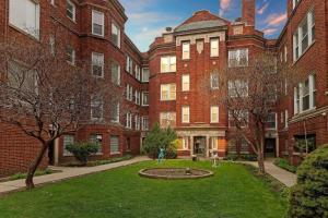 a courtyard of a large brick building with a fountain at City Charm Studio Apt close to Shops - Ashland 04 in Chicago