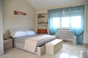 - une chambre avec un lit doté de rideaux bleus et d'une fenêtre dans l'établissement Attico luminoso terrazza Metro A Aria Cond WiFi, à Rome