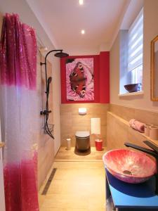 baño con ducha y pared roja en Märchenhaft urlauben auf dem Alpakahof en Rambow