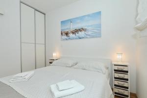 ein Schlafzimmer mit einem weißen Bett mit zwei Handtüchern darauf in der Unterkunft Apartment and room Mare in Zadar