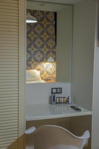 een witte stoel in een kamer met een spiegel bij Aparthotel Ano in Acharavi