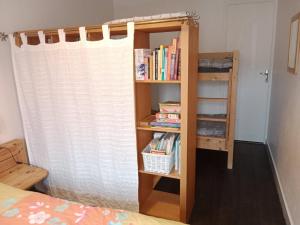 a book shelf next to a bed with books at Vitré centre Ville bel appartement a découvrir in Vitré +3 photos