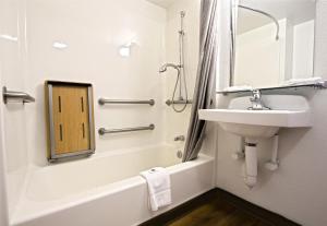 a bathroom with a sink and a bath tub with a mirror at Motel 6-East Brunswick, NJ in East Brunswick