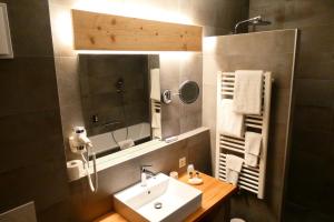bagno con lavandino e specchio di Hôtel St-Georges Romont a Romont