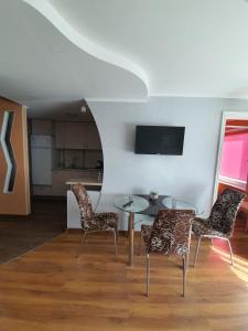 a living room with a table and chairs and a kitchen at Vidumgrāvja apartamenti in Ventspils