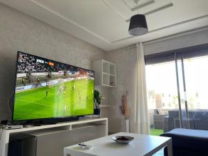En tv och/eller ett underhållningssystem på Appartement de LUXE Marina SAIDIA avec vue sur PISCINE Résidence TAMARIS