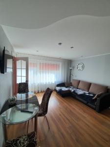 a living room with a couch and a glass table at Vidumgrāvja apartamenti in Ventspils