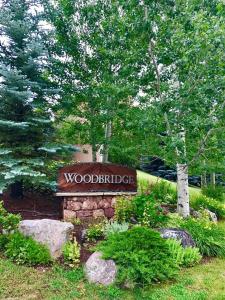 a sign for a woodridge sign in a garden at Woodbridge Condo by Snowmass Vacations in Snowmass Village