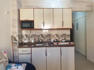 a kitchen with white cabinets and a microwave at شاليه للعائلات غرفة وريسيبشن بمنتجع ريتال فيو الساحل الشمالى in El Alamein