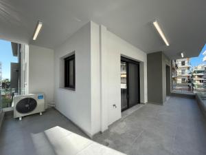 Modern Apartments near Marina Flisvos في أثينا: غرفة مع تلفزيون في طابق مع نوافذ