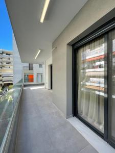 - un balcon dans un bâtiment avec de grandes fenêtres dans l'établissement Modern Apartments near Marina Flisvos, à Athènes