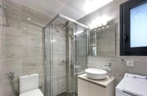 a bathroom with a shower and a toilet and a sink at Modern Apartments near Marina Flisvos in Athens