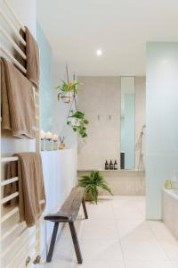 a bathroom with a bench and a tub at Architectural Home, Pool Oasis/ Steps from Trendy Chapel St. in Melbourne +27 photos