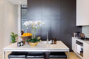 a kitchen with a table with flowers and oranges at Architectural Home, Pool Oasis/ Steps from Trendy Chapel St. in Melbourne