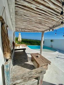 a patio with a wooden bench and a pool at Atalaya Villas Nusa Penida in Nusa Penida