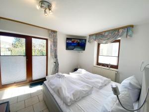 a bedroom with a large white bed and two windows at Ferienwohnungen Stadtmitte - Fewo 3 in Sassnitz
