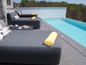 a black couch sitting next to a swimming pool at Cà Veia in Vrbnik