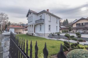 a white house with a fence in a yard at Vila Samokres sa bazenom in Banja Koviljača