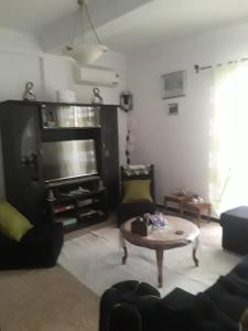 a living room with a couch and a coffee table at Bel Appartement Kouba Centre in Alger