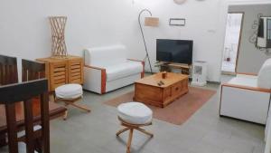 a living room with a tv and a coffee table at Villa Saint-Sulpice Apt avec piscine in Yaoundé