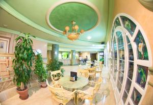 eine Lobby mit einem Tisch, Stühlen und einem Kronleuchter in der Unterkunft Los Angeles Hotel & Spa in Granada