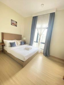 a bedroom with a bed and a large window at MrK Penthouse at Timurbay in Kuantan