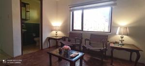 uma sala de estar com cadeiras, uma mesa e uma janela em Departamento Marlene em Cuenca
