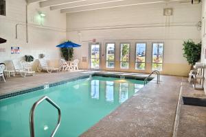 einen Pool mit Stühlen, einem Tisch und einem Sonnenschirm in der Unterkunft Motel 6-Billings, MT - North in Billings