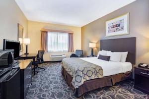 a hotel room with a bed and a flat screen tv at Baymont by Wyndham Casper East in Evansville