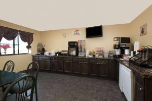 a room with a kitchen with a counter with a coffee maker at Super 8 by Wyndham Topeka/Wanamaker RD/I-70 in Topeka