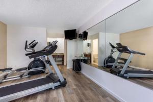 a gym with two treadmills and a mirror at Baymont by Wyndham Tallahassee in Tallahassee