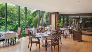 a restaurant with white tables and chairs and windows at Hyatt Regency Dar es Salaam, The Kilimanjaro in Dar es Salaam