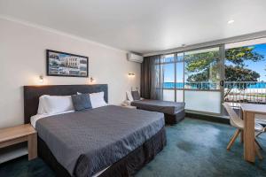 um quarto de hotel com uma cama, uma secretária e uma janela em Quality Inn Napier em Napier