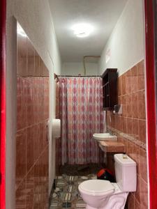 y baño con aseo, lavabo y ducha. en Mandala’s Hostal, en San Pedro La Laguna