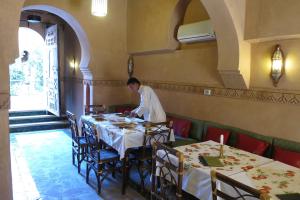 NkobKasbah Hotel Ait Omar的站在餐厅桌子旁的人