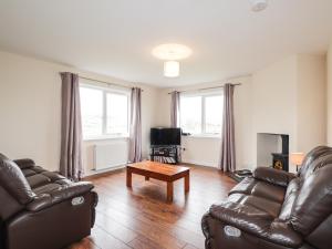 a living room with two leather couches and a coffee table at Hilltop in Clachtoll