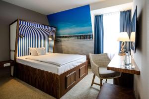 a bedroom with a bed and a desk and a chair at Dorint Hotel Alzey/Worms in Alzey +75 photos