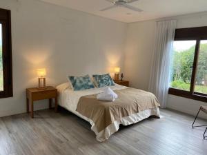 a bedroom with a bed with two lamps and a window at Acogedora y amplia casa en Salta! in Salta