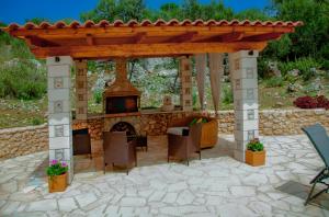 een tuinhuisje met een open haard in een patio bij Direti villa in Kalamitsi Amygdali