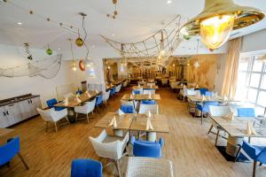 アルツァイにあるDorint Hotel Alzey/Wormsの木製テーブルと青い椅子が備わるレストラン