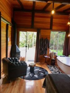 a living room with a tub and a couch and a fireplace at Sentiero Cabanas Boutique in Urubici