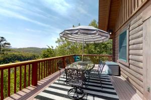 een tafel en stoelen op een balkon met een parasol bij Eagles Nest in New Tazewell