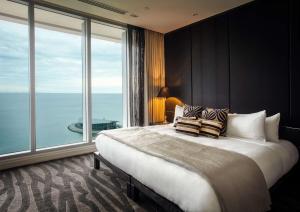 a bedroom with a large bed with a large window at Grand Papua Hotel, a member of Radisson Individuals in Port Moresby