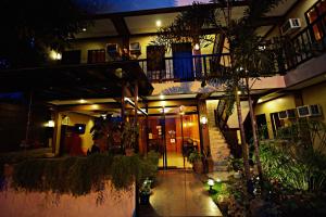 a building with a balcony and a courtyard at night at Pacific Palm Suites Davao powered by Cocotel in Davao City