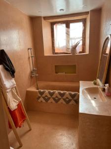 uma casa de banho com um chuveiro, um lavatório e uma janela em Berberbayt lodge maison privé em Tinghir