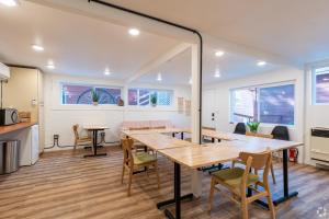 a dining room with tables and chairs and windows at Grand Pine Cabins in Wrightwood