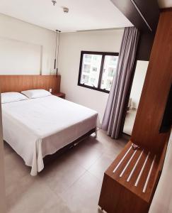 a bedroom with a white bed and a window at Salinas Premium Resort in Salinópolis