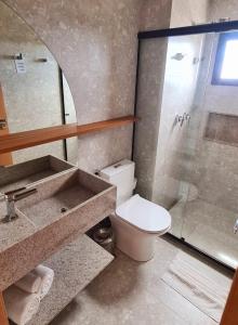 a bathroom with a toilet and a glass shower at Salinas Premium Resort in Salinópolis