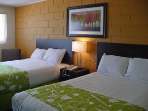 a hotel room with two beds and a phone at Westgate Inn in Portage La Prairie
