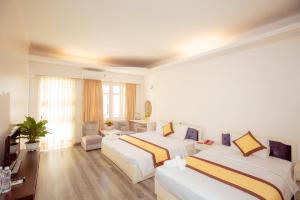 a hotel room with two beds and a living room at Mercury Hotel & Apartment in Vung Tau